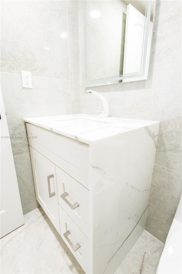 bathroom with vanity and tile walls