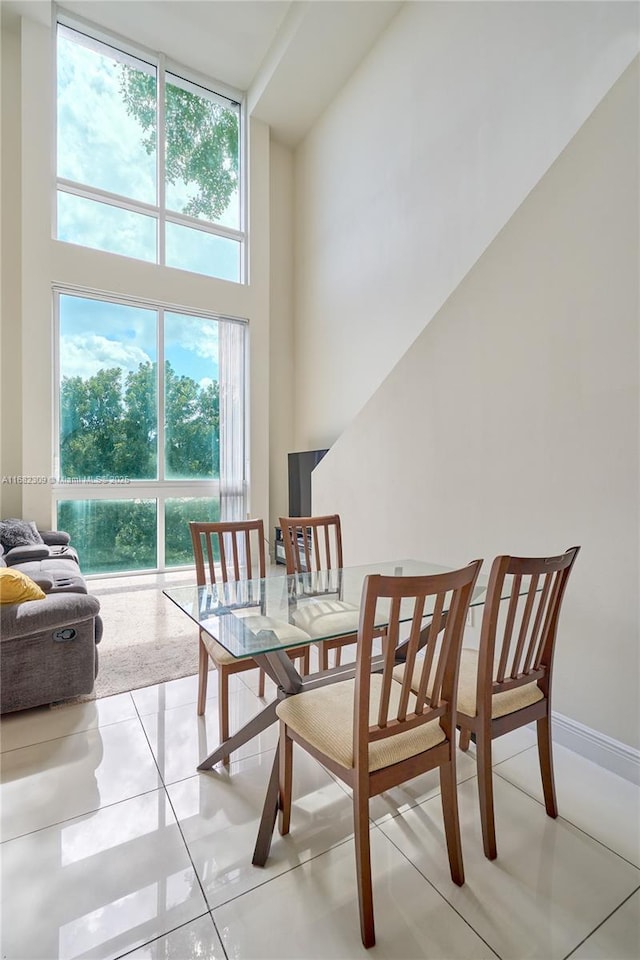 tiled dining space featuring a high ceiling