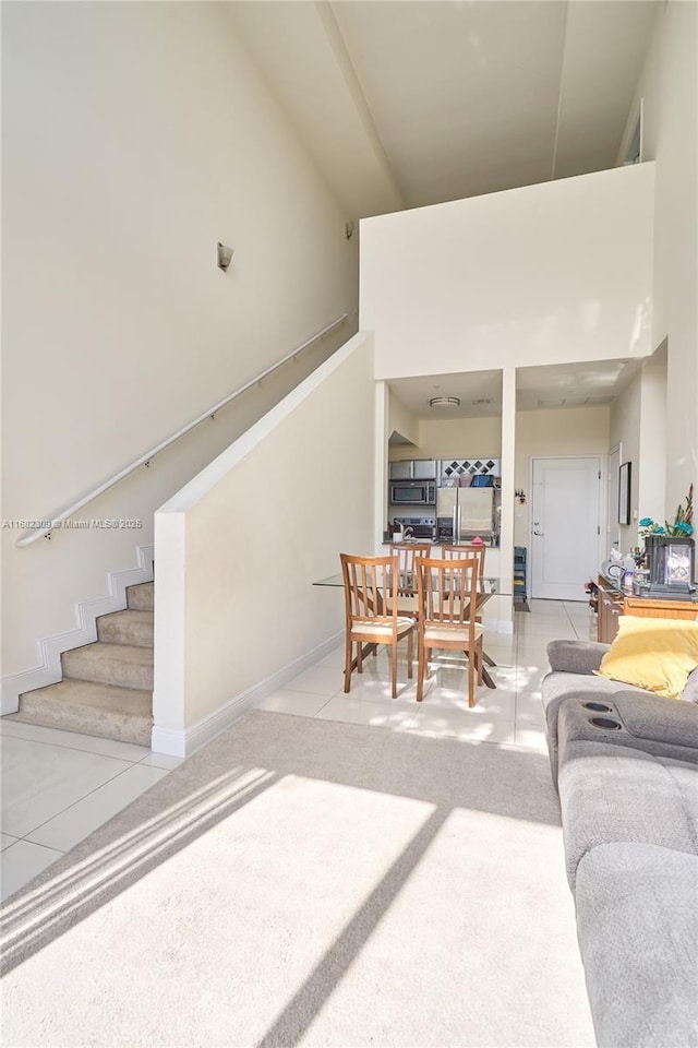 tiled living room featuring a towering ceiling