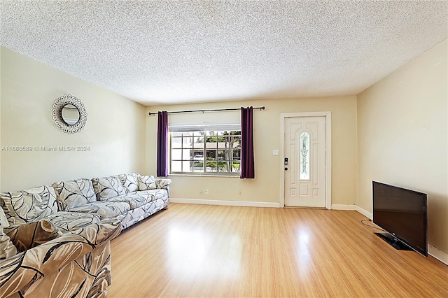 living room with light hardwood / wood-style floors and a textured ceiling