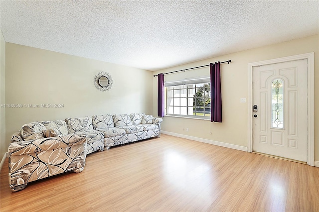 living room with a textured ceiling and light wood-type flooring