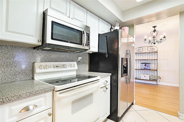 kitchen featuring backsplash, appliances with stainless steel finishes, light hardwood / wood-style flooring, and white cabinetry