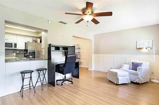 office with sink, ceiling fan, and light hardwood / wood-style flooring