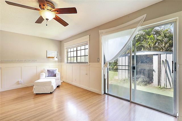 unfurnished room featuring light hardwood / wood-style floors, a textured ceiling, plenty of natural light, and ceiling fan