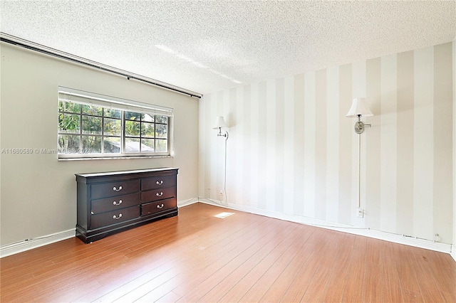 empty room featuring a textured ceiling and hardwood / wood-style flooring