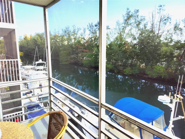 sunroom featuring a water view