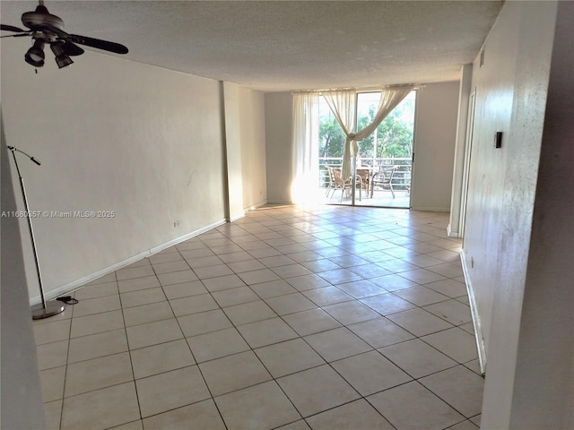 unfurnished room with ceiling fan, light tile patterned flooring, and a textured ceiling