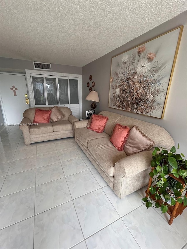 living room featuring tile patterned flooring and a textured ceiling