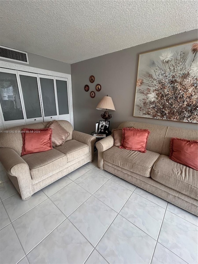 living room with tile patterned flooring and a textured ceiling