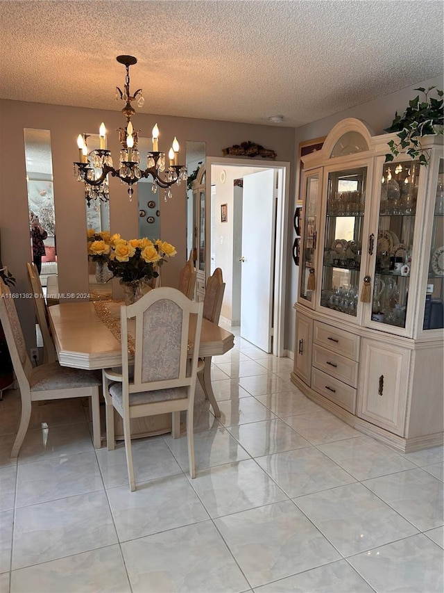 dining room with light tile patterned floors, a textured ceiling, and a notable chandelier