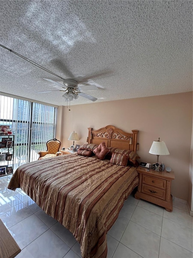 tiled bedroom with ceiling fan, access to exterior, and a textured ceiling