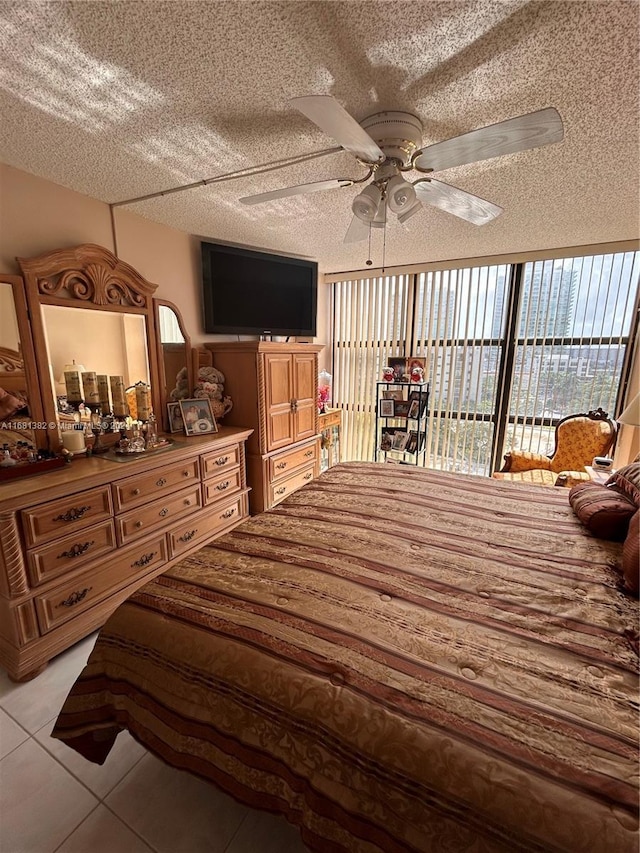 tiled bedroom with a textured ceiling and ceiling fan