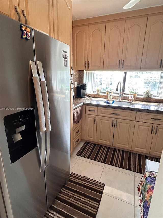 kitchen with light brown cabinetry, stainless steel fridge with ice dispenser, sink, and light tile patterned flooring