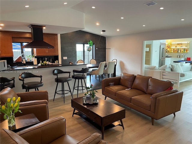 living room featuring light hardwood / wood-style floors and vaulted ceiling