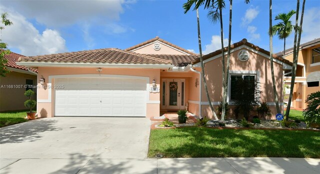 view of front of property with concrete driveway, a tiled roof, an attached garage, and stucco siding