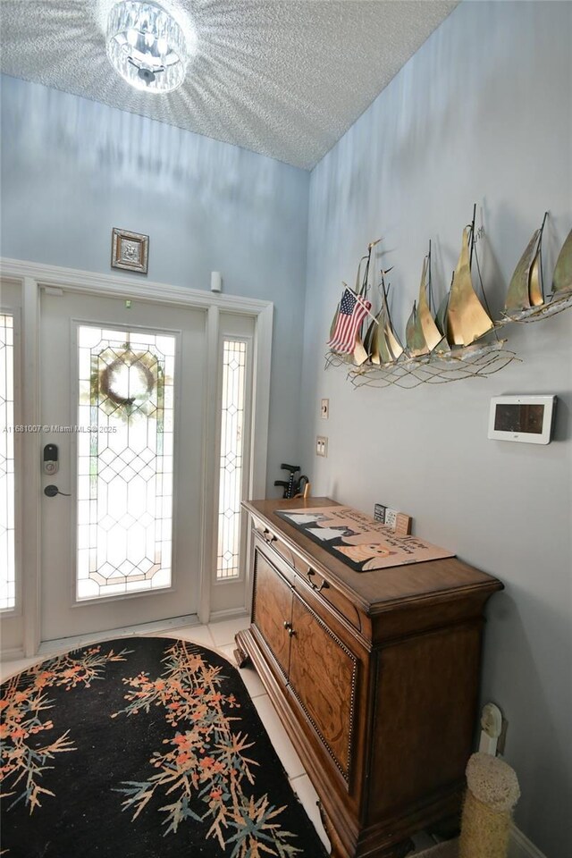 tiled entryway with a textured ceiling