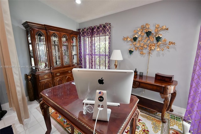 office area with lofted ceiling and light tile patterned floors