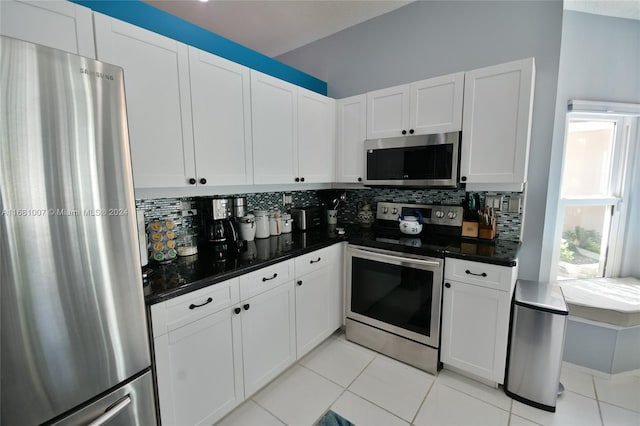 kitchen featuring appliances with stainless steel finishes, white cabinetry, light tile patterned floors, and backsplash