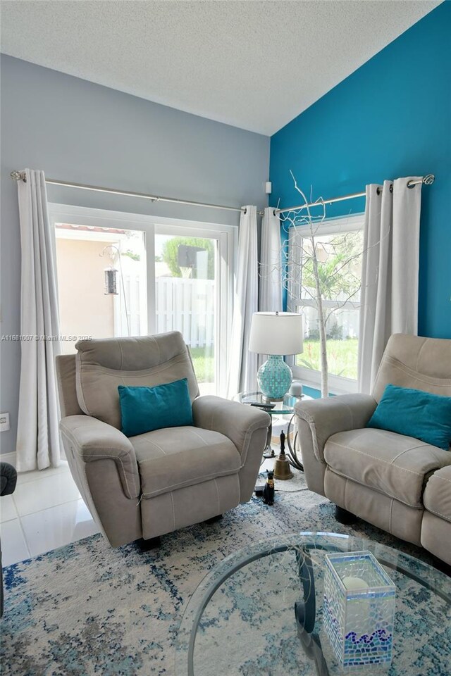 living room featuring a textured ceiling, a healthy amount of sunlight, and tile patterned floors