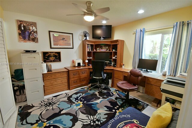 office featuring built in desk, ceiling fan, and light tile patterned floors