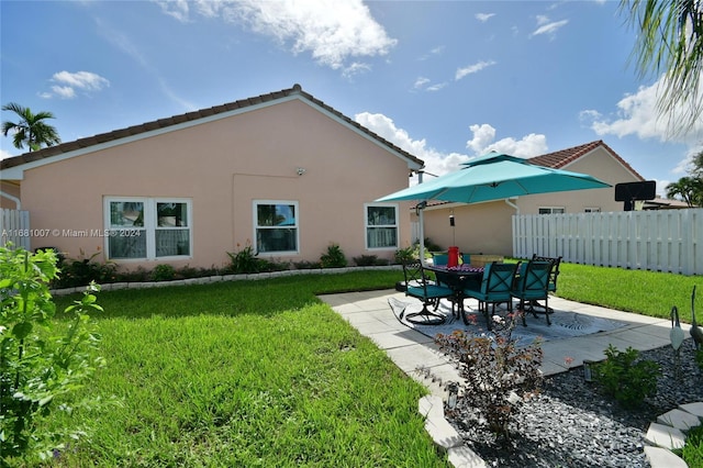 back of property with a patio area and a lawn