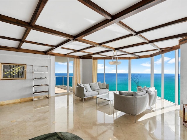 living room featuring a water view, coffered ceiling, and a wall of windows