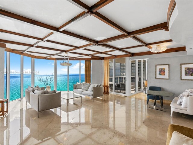 living room featuring floor to ceiling windows, a water view, coffered ceiling, and plenty of natural light