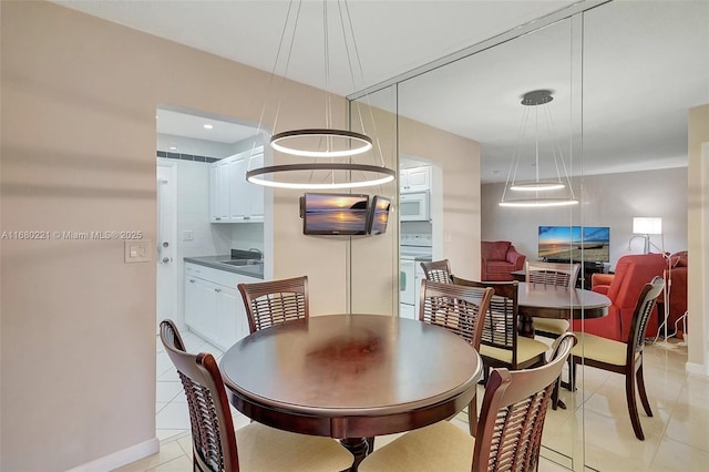 dining space featuring sink and light tile patterned floors