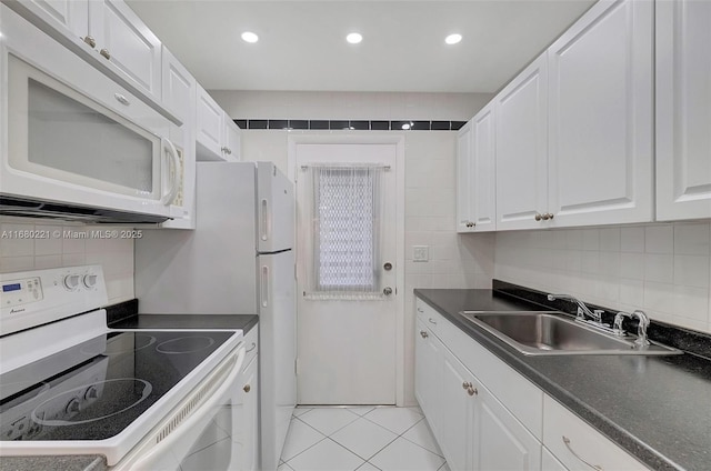 kitchen with sink, light tile patterned floors, white cabinets, white appliances, and backsplash