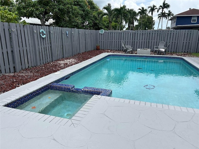 view of swimming pool with an in ground hot tub