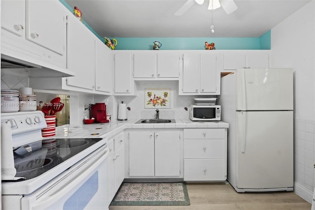 kitchen with light hardwood / wood-style floors, sink, white cabinetry, white appliances, and tasteful backsplash