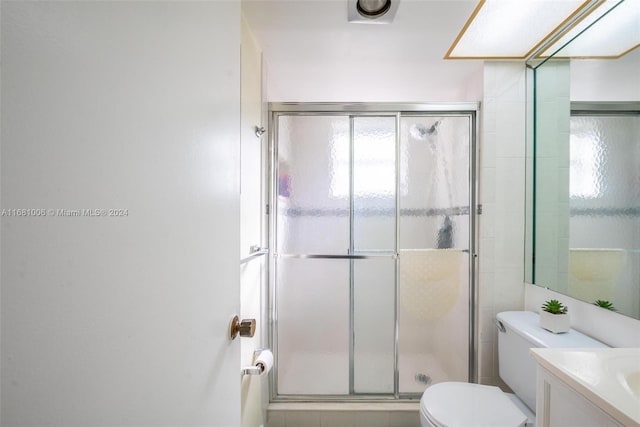 bathroom featuring vanity, toilet, and an enclosed shower