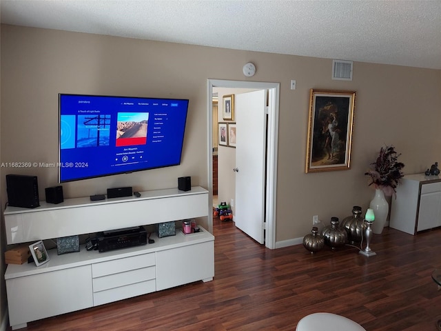 living room with a textured ceiling and dark hardwood / wood-style floors