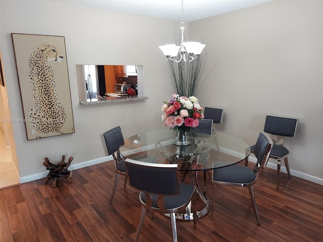 dining room with a notable chandelier and dark hardwood / wood-style flooring