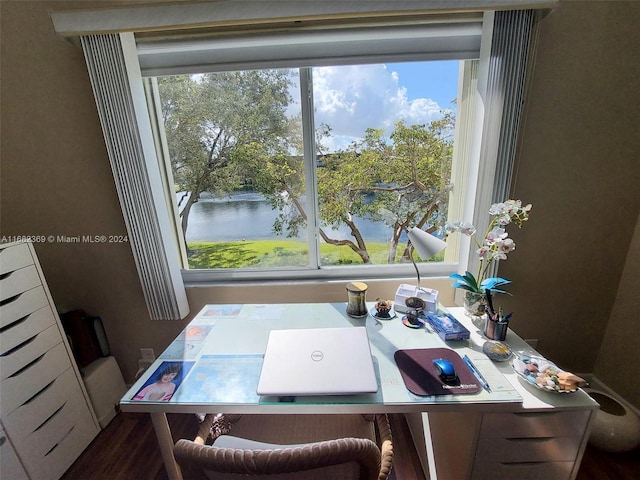 dining room with dark hardwood / wood-style floors and a water view