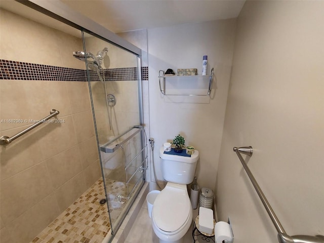 bathroom with toilet, a shower with shower door, and tile patterned flooring