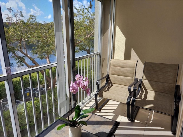 sunroom featuring a water view