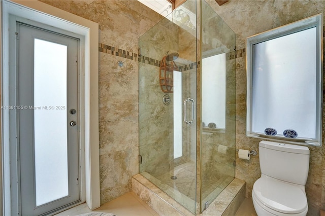 bathroom with a stall shower and toilet