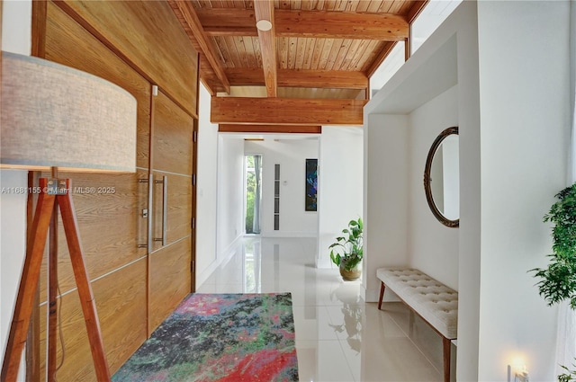 hallway with wooden ceiling, beamed ceiling, and tile patterned floors