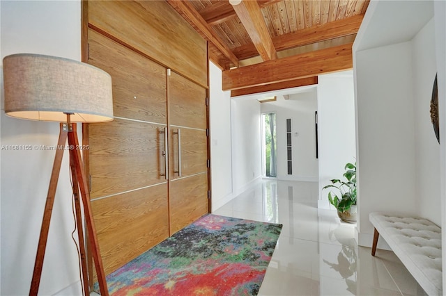 hallway with wood ceiling, tile patterned flooring, and beam ceiling