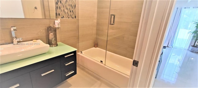 full bathroom featuring combined bath / shower with glass door and vanity