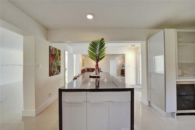 interior space with wine cooler, light tile patterned flooring, recessed lighting, and baseboards