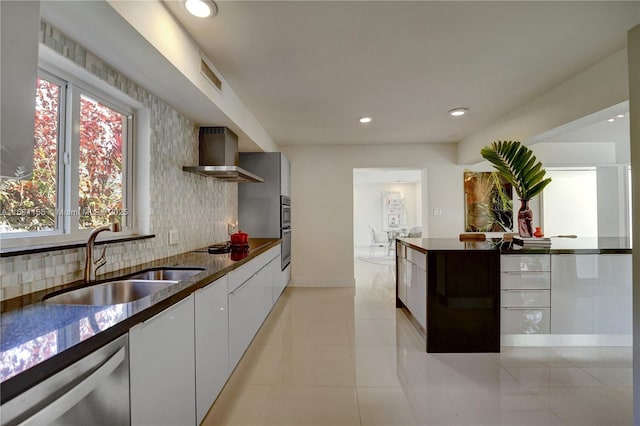 kitchen featuring decorative backsplash, dishwasher, wall chimney exhaust hood, modern cabinets, and a sink