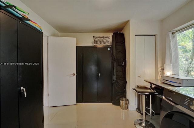 interior space featuring light tile patterned flooring and washer / dryer