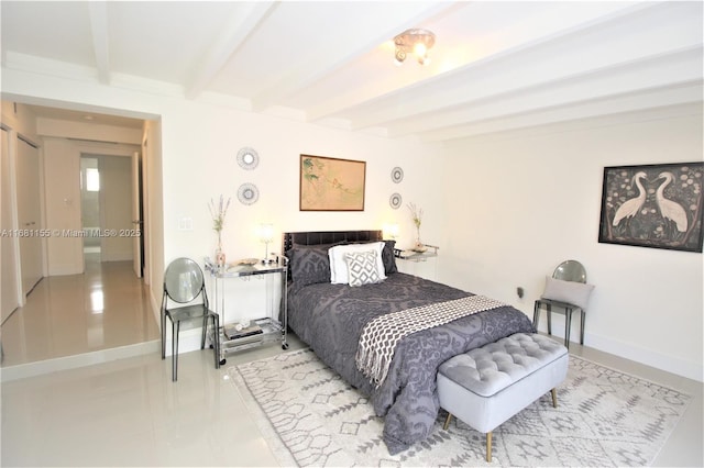 bedroom featuring baseboards and beamed ceiling