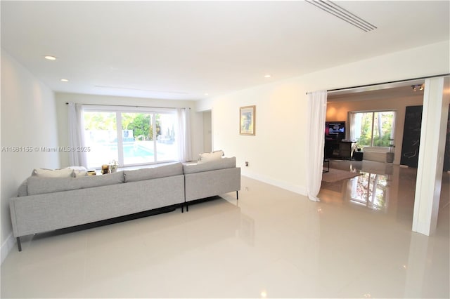 living room featuring baseboards and recessed lighting