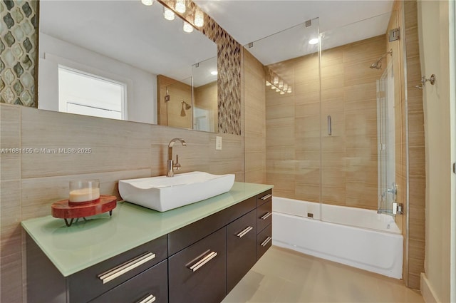 full bath with shower / bath combination with glass door, tasteful backsplash, tile walls, and vanity