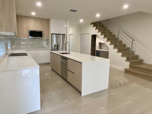 kitchen featuring a center island, white cabinets, stainless steel appliances, and sink