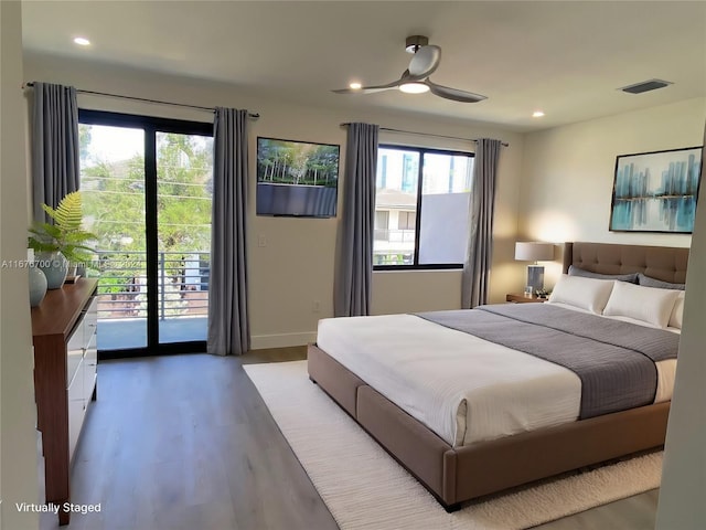 bedroom with hardwood / wood-style floors, access to outside, multiple windows, and ceiling fan