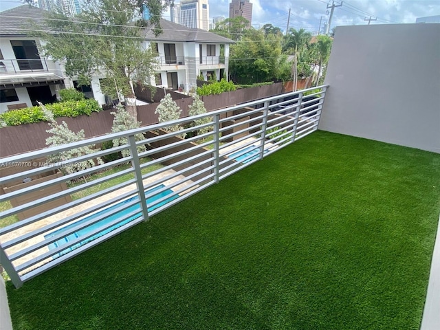 view of yard with a balcony and a fenced in pool